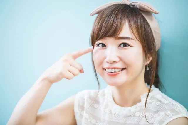 目を指さす女性