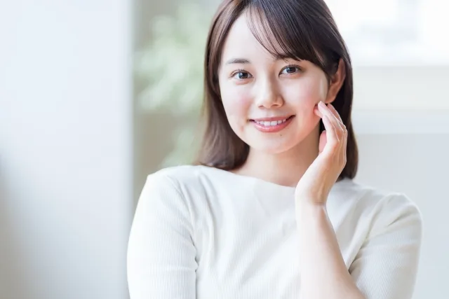 左手を頬に沿える女性