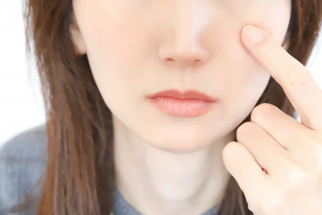 目元をさす女性