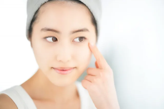 目を指さしている女性