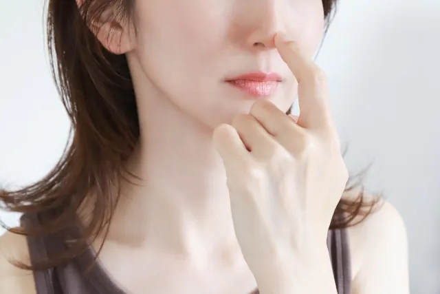 鼻を触る女性