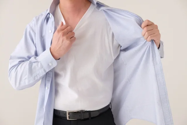 服を脱ぐ男性