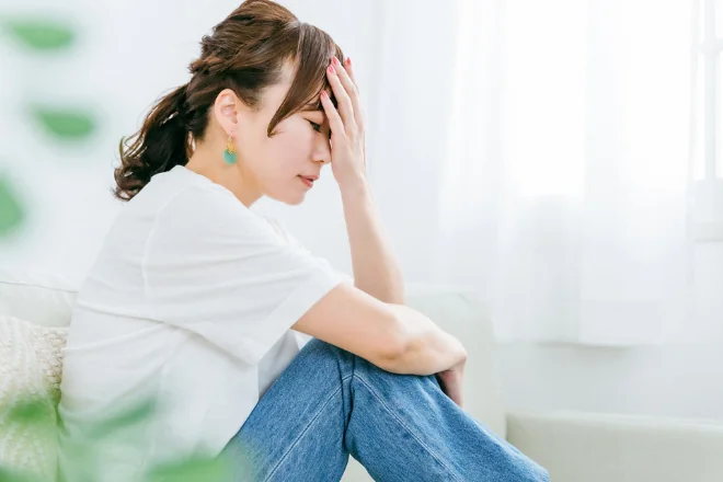 座って頭を抱える女性