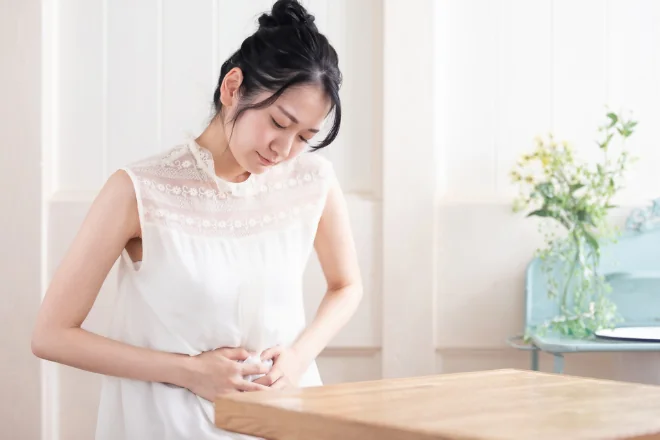 下腹部に手を当てる女性