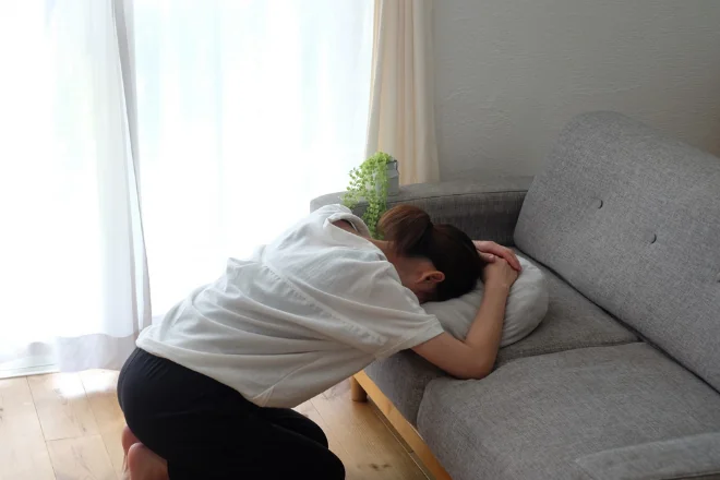 ソファでうつぶせに横たわる女性