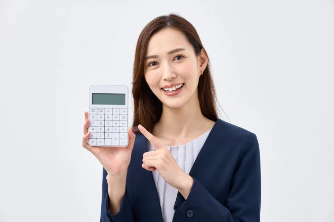 電卓を持つスーツの女性
