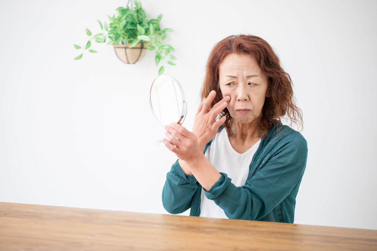 鏡で目元を確認する女性