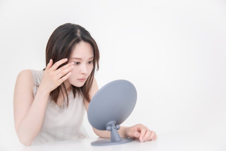 鏡で目元を確認する女性